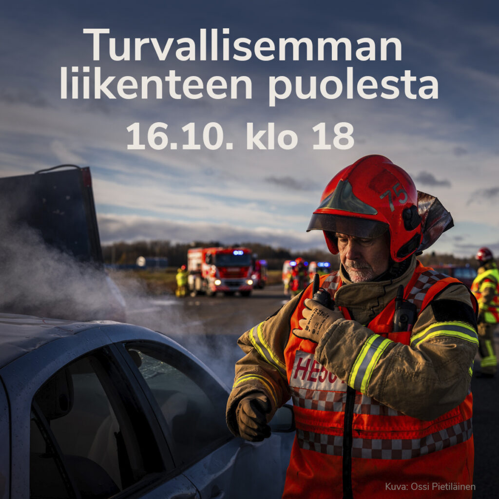 Palomies oranssiruskeassa asussa ja kypärässä vakava ilme kasvoilla. Taustalla paloautoja. Palomiehen vierellä savuava henkilöauto.